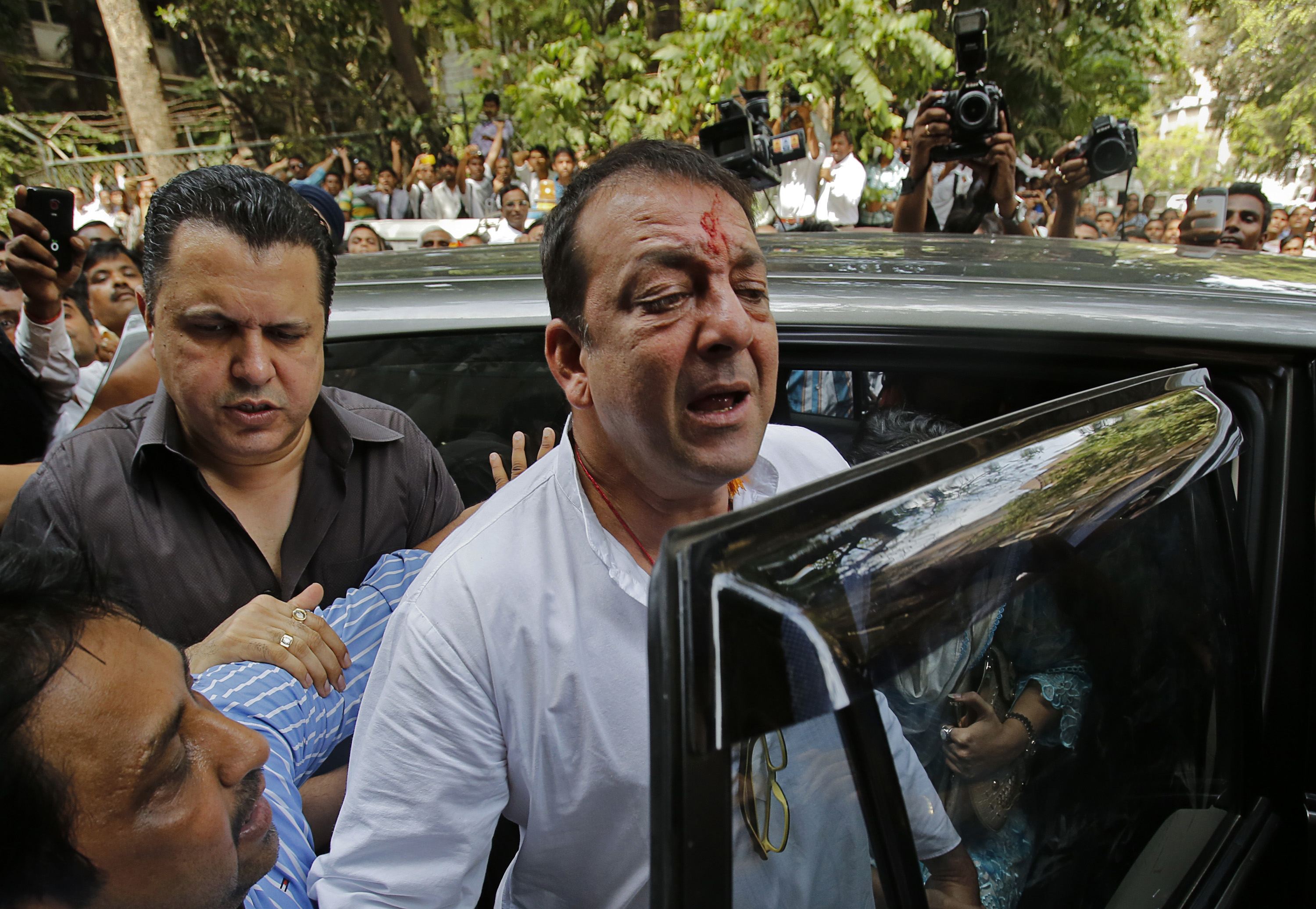 Bollywood actor Sanjay Dutt gets out of a vehicle as he arrives to surrender at a court in Mumbai